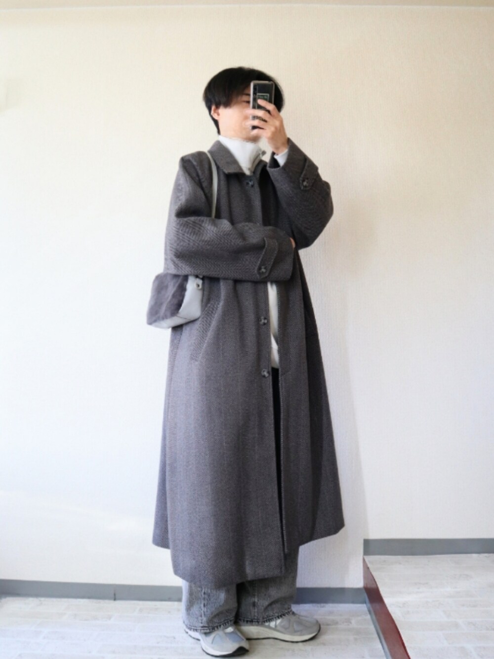 グレー系のショルダーバッグ、グレー系のステンカラーコート、グレー系のスウェットを着用したメンズの冬コーディネートの2枚目の写真