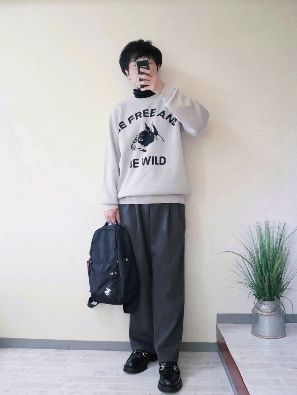 ベージュ系のニット/セーター、グレー系のその他パンツ、ブラック系のバックパック/リュックを着用したメンズの冬コーディネートの3枚目の写真