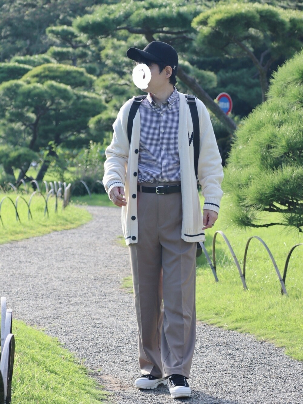 ブラック系のバックパック/リュック、ベージュ系のスラックス、ブラック系のスニーカーを着用したメンズの秋コーディネートの2枚目の写真