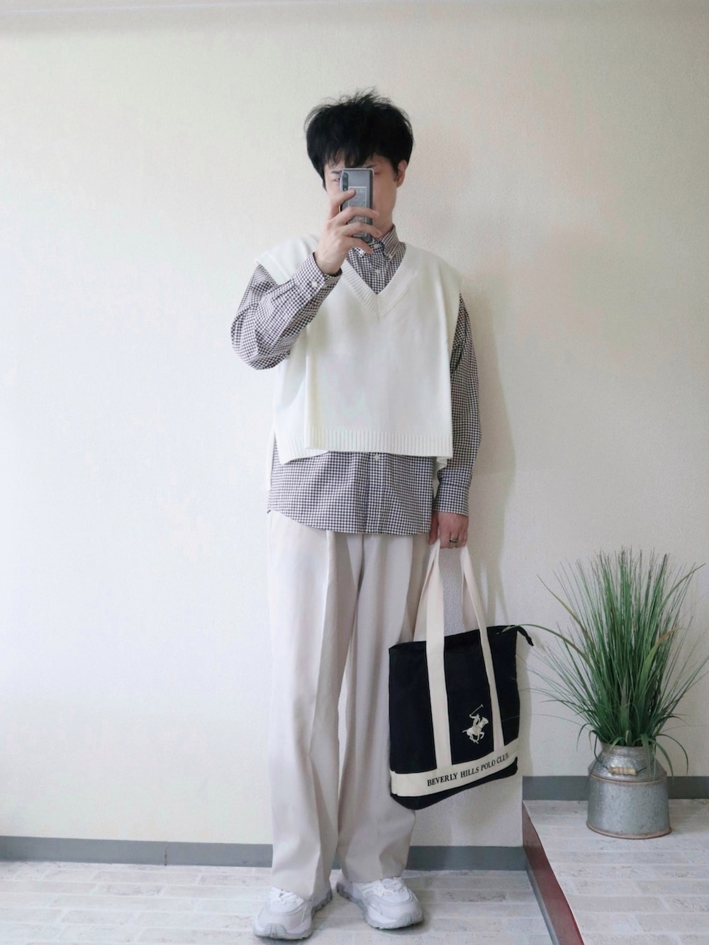 ホワイト系のベスト、ブラウン系のシャツ/ブラウス、ブラック系のトートバッグを着用したメンズの秋コーディネートの2枚目の写真