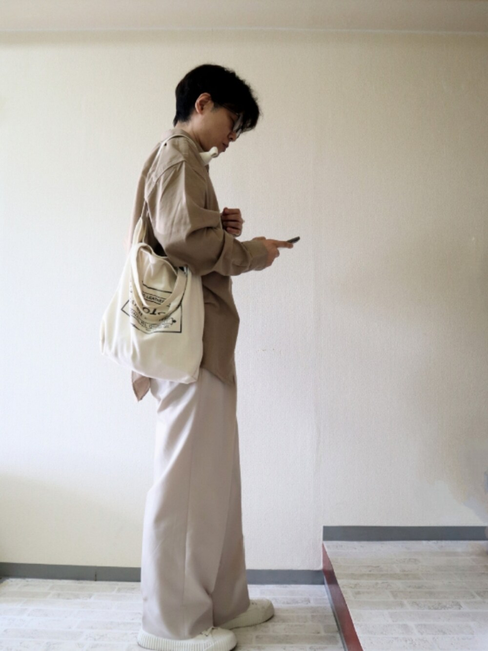 ベージュ系のシャツ/ブラウス、ホワイト系のスニーカー、ホワイト系のベルトを着用したメンズの秋コーディネートの2枚目の写真