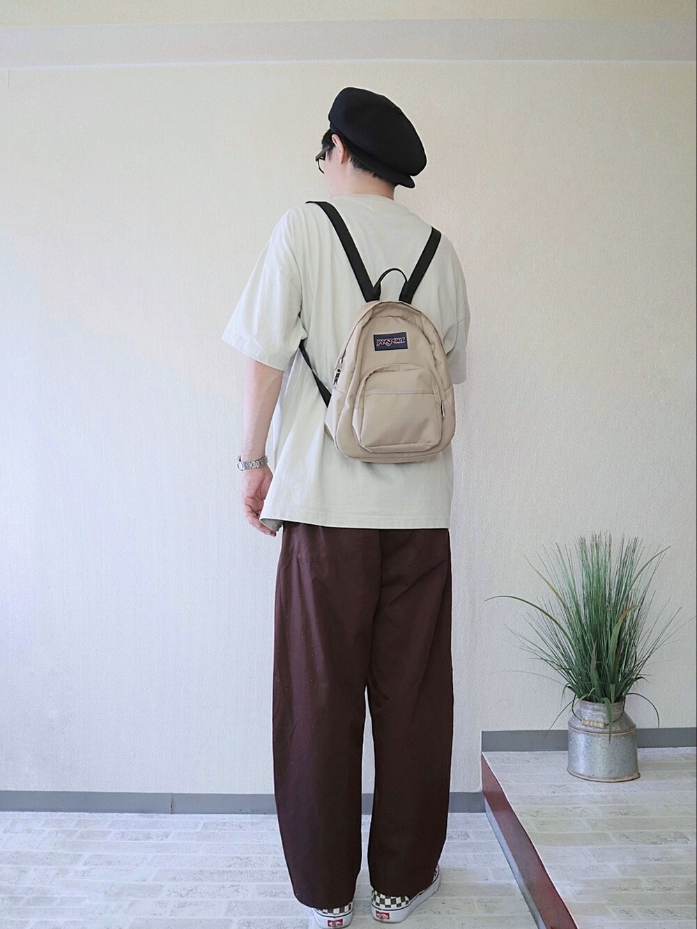 ブラウン系のその他パンツ、ブラウン系のスリッポン、ベージュ系のバックパック/リュックを着用したメンズの夏コーディネートの2枚目の写真