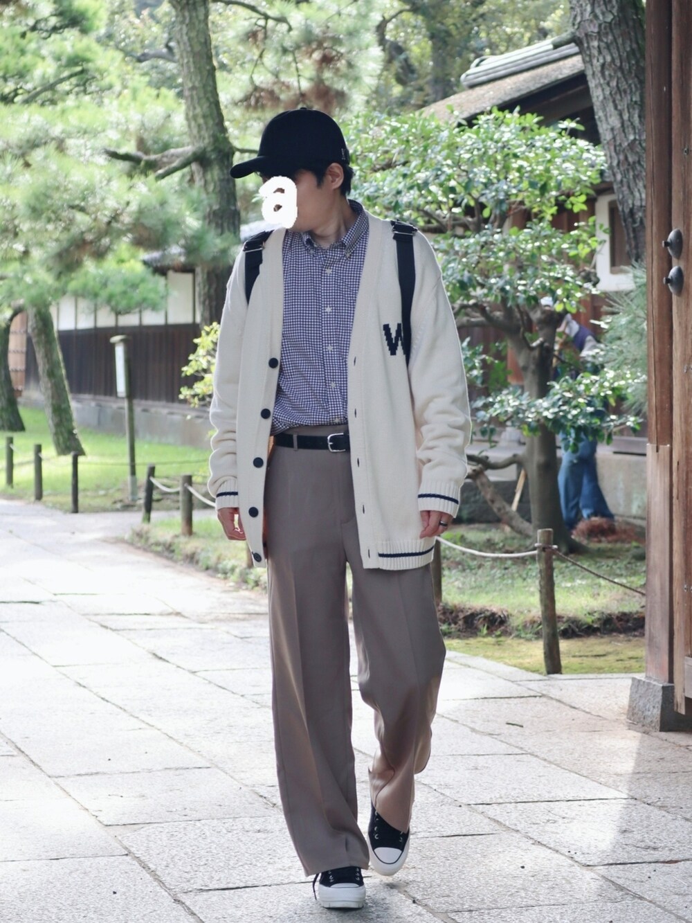 ブラック系のバックパック/リュック、ベージュ系のスラックス、ブラック系のスニーカーを着用したメンズの秋コーディネートの3枚目の写真