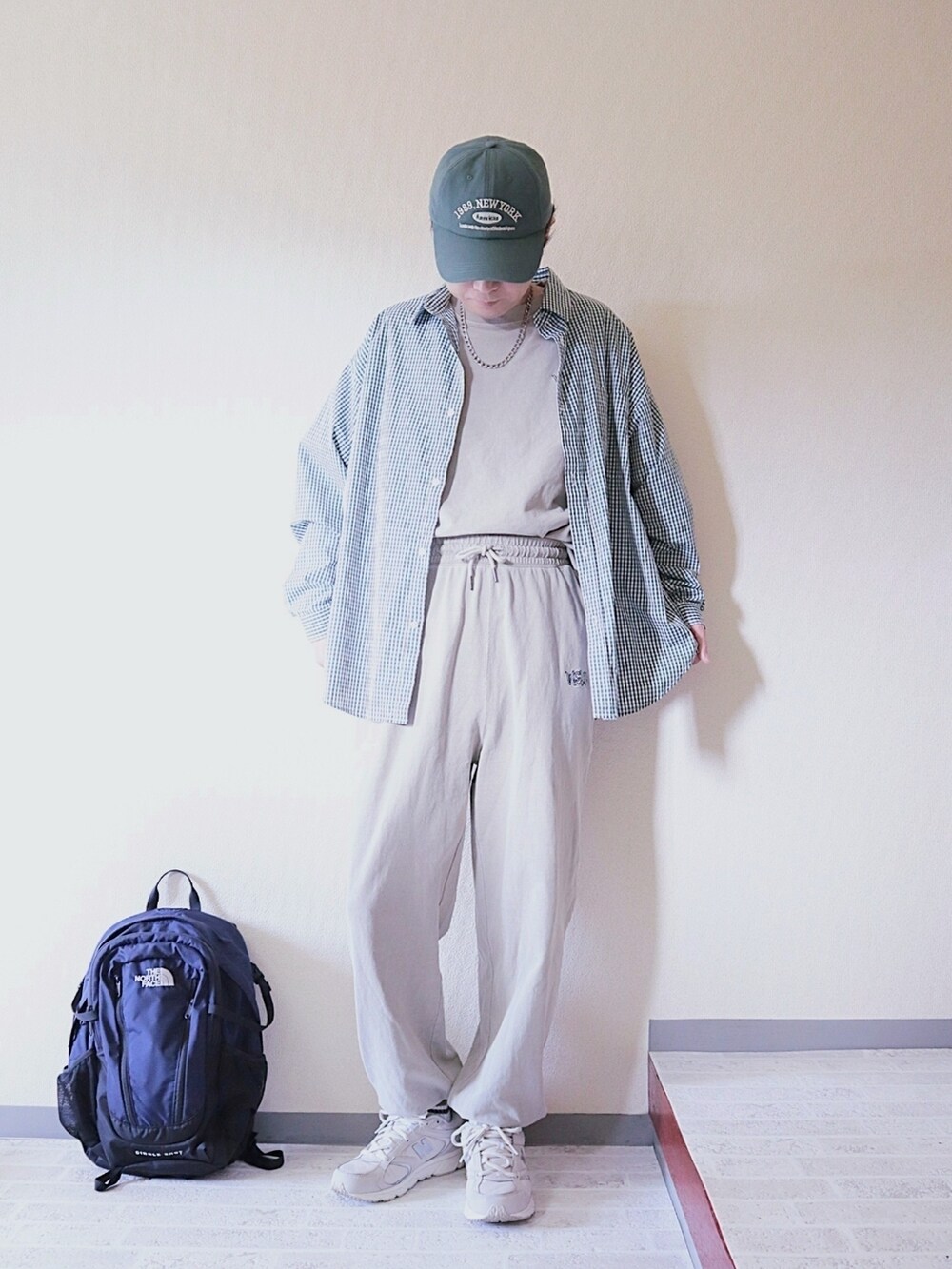 ベージュ系のスウェットパンツ、ベージュ系のTシャツ/カットソー、グレー系のスニーカーを着用したメンズの春コーディネートの2枚目の写真