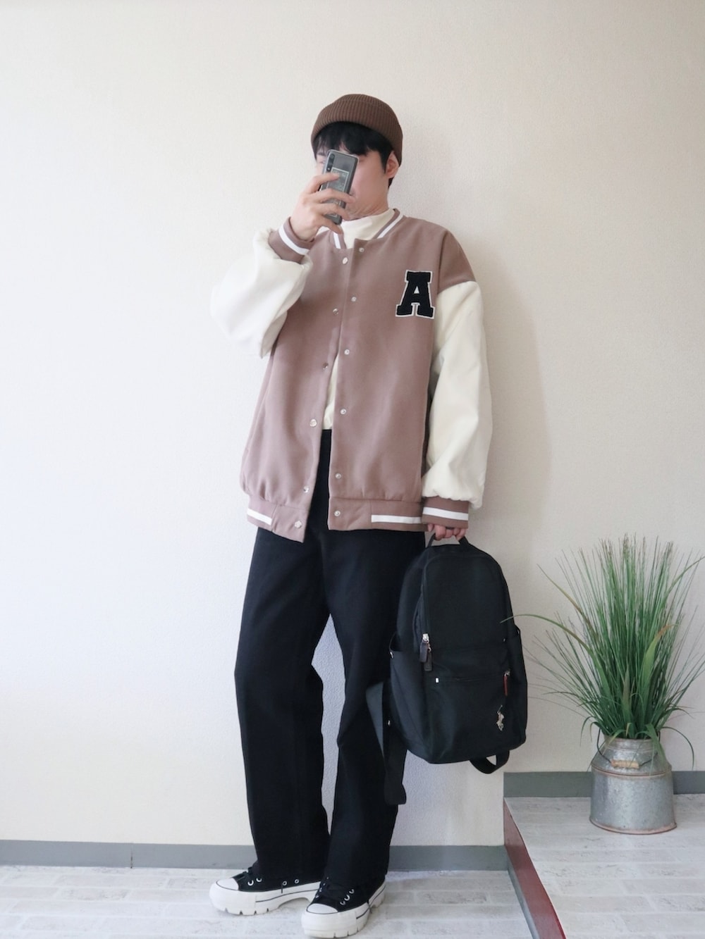 ブラウン系のスタジャン、ブラック系のデニムパンツ、ブラック系のバックパック/リュックを着用したメンズの秋コーディネートの2枚目の写真