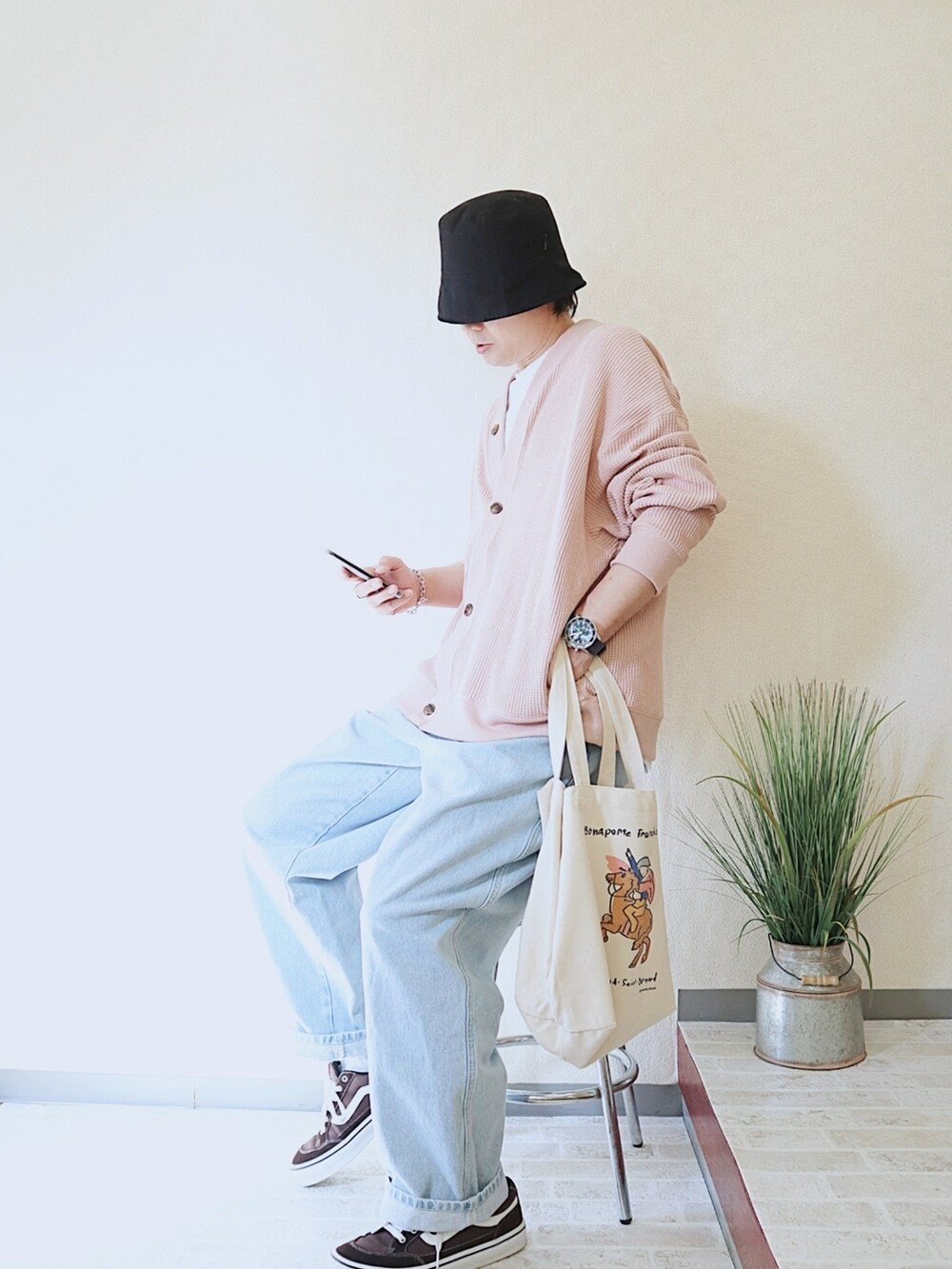 ピンク系のカーディガン/ボレロ、ブラック系のハット、ブルー系のアナログ腕時計を着用したメンズの春コーディネートの3枚目の写真