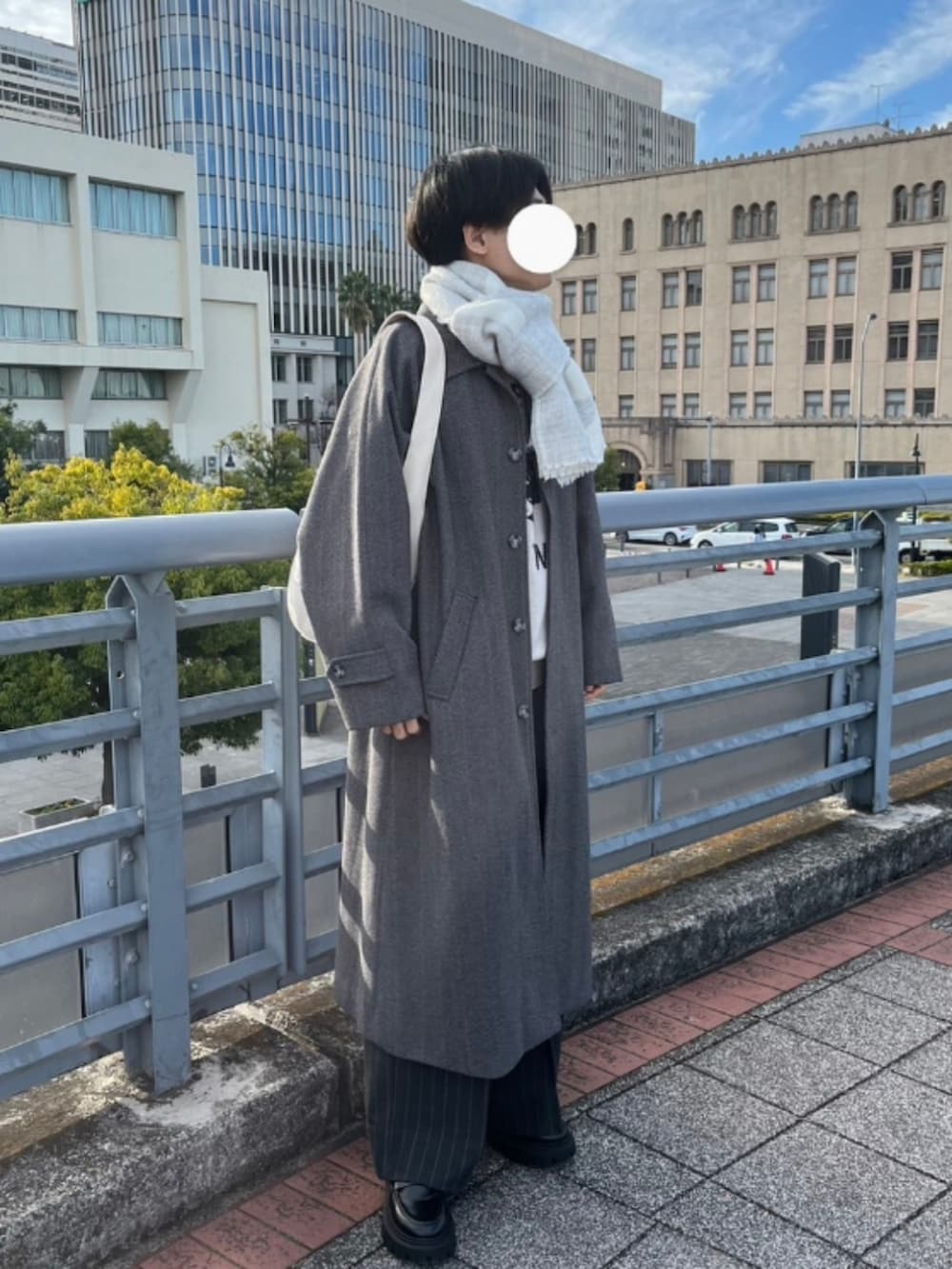 グレー系のステンカラーコート、ブラック系のローファー、グレー系のその他パンツを着用したメンズの冬コーディネートの2枚目の写真