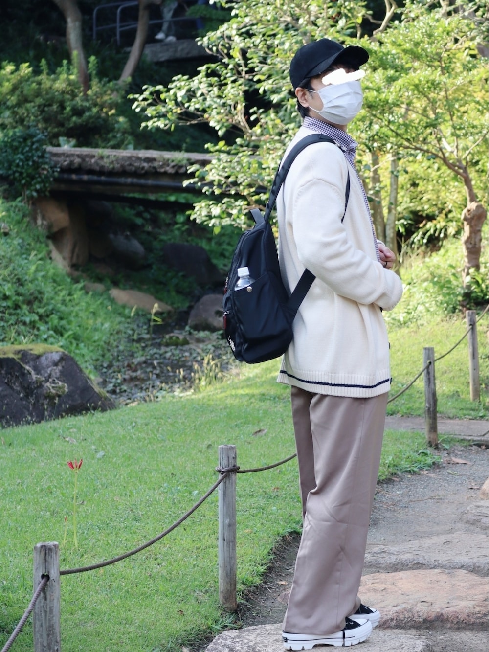 ブラック系のバックパック/リュック、ベージュ系のスラックス、ブラック系のスニーカーを着用したメンズの秋コーディネートの4枚目の写真