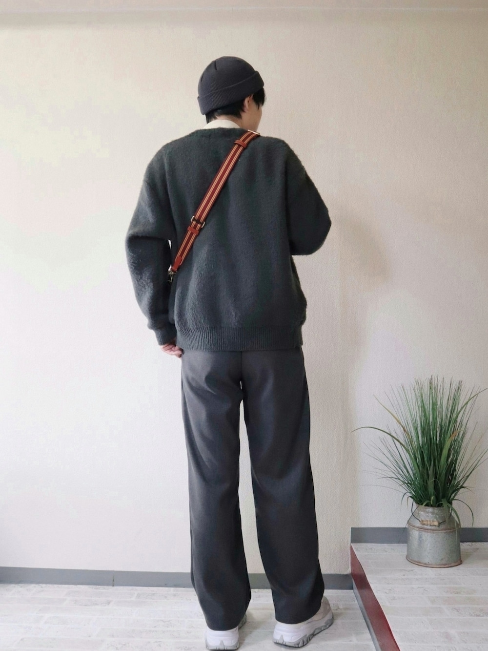 グリーン系のカーディガン/ボレロ、グレー系のその他パンツ、ブラウン系のショルダーバッグを着用したメンズの秋コーディネートの3枚目の写真