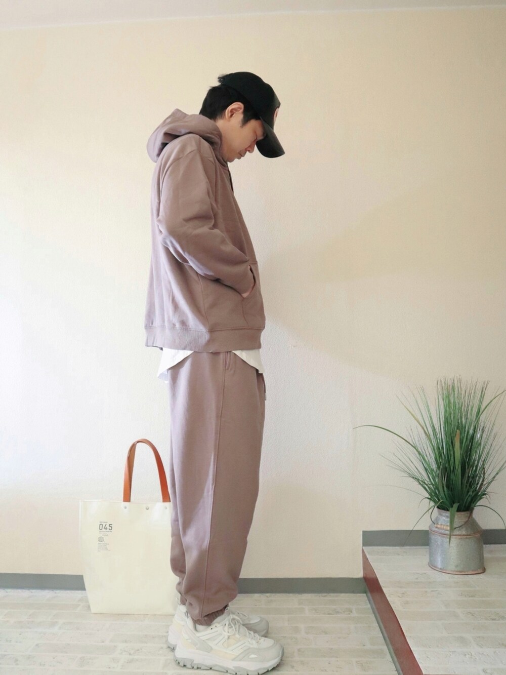 ベージュ系のパーカー、ベージュ系のスウェットパンツ、ホワイト系のトートバッグを着用したメンズの秋コーディネートの2枚目の写真