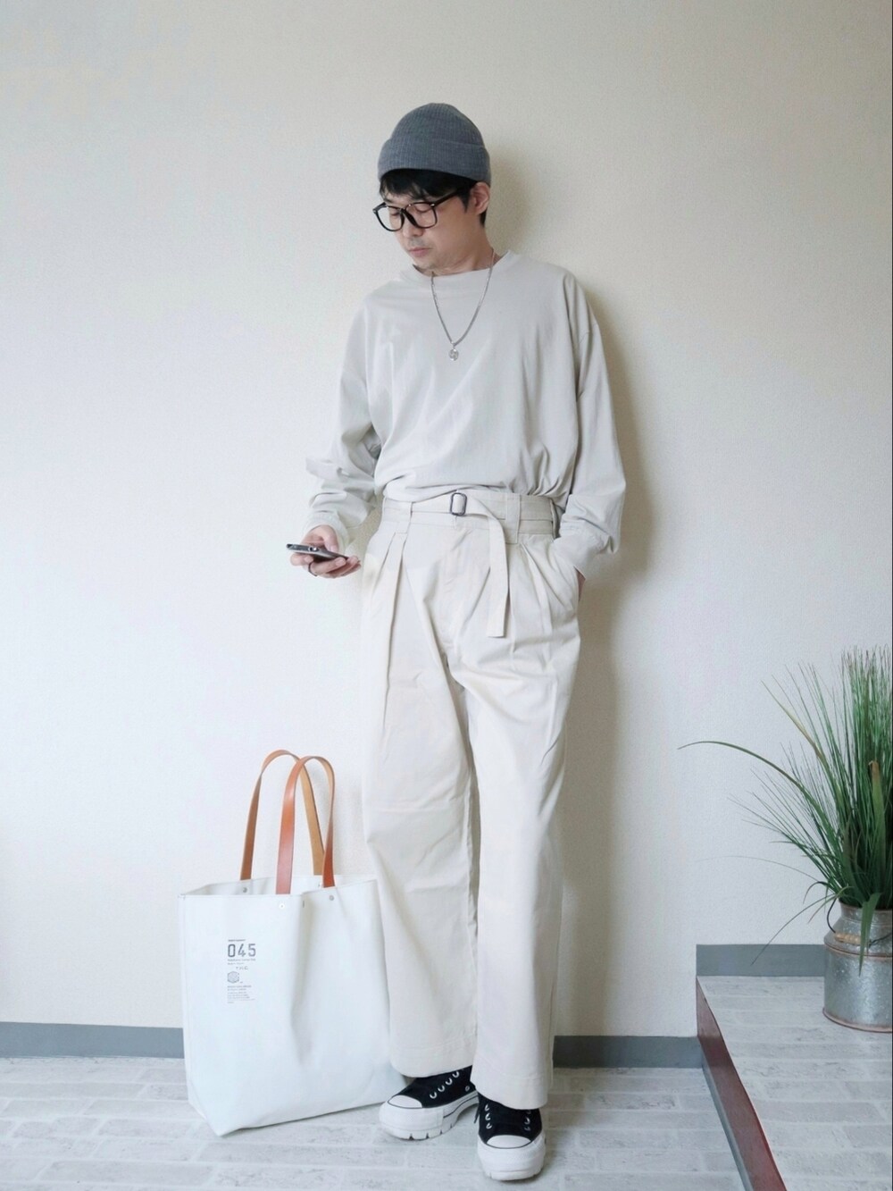 ホワイト系のその他パンツ、ブラック系のスニーカー、ホワイト系のトートバッグを着用したメンズの秋コーディネートの2枚目の写真
