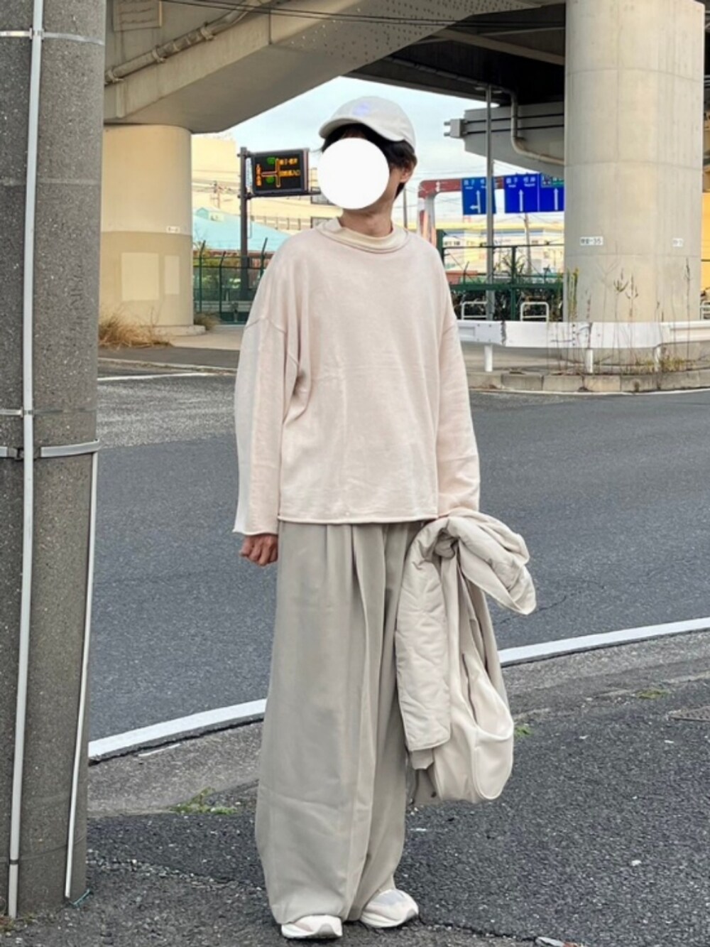 ホワイト系のショルダーバッグ、ホワイト系のニット/セーター、ベージュ系のスラックスを着用したメンズの冬コーディネートの3枚目の写真