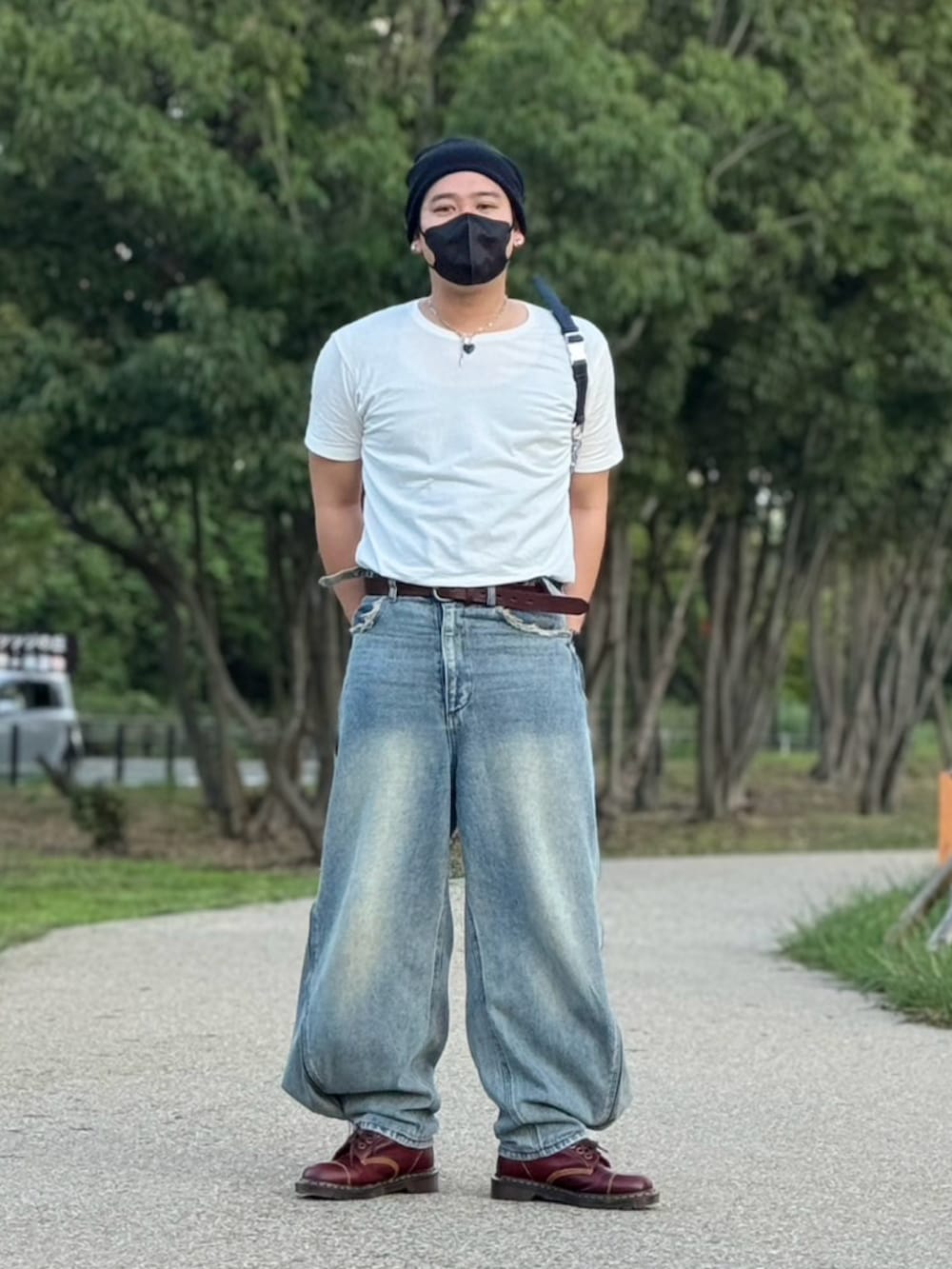 ホワイト系のTシャツ/カットソー、ブルー系のデニムパンツ、レッド系のブーツを着用したメンズの秋コーディネートの2枚目の写真