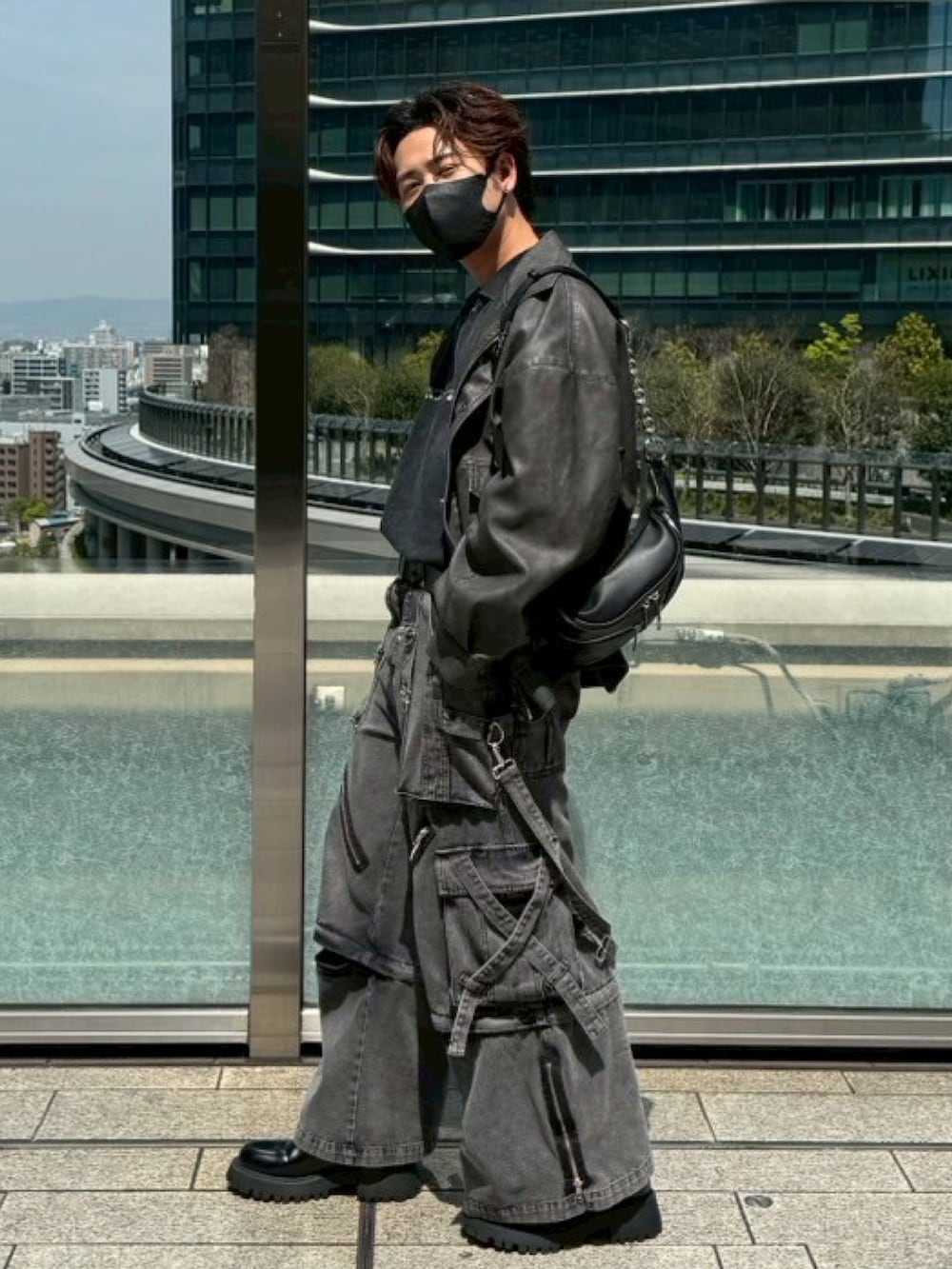ブラック系のブルゾン、ブラック系のTシャツ/カットソー、ブラック系のカーゴパンツを着用したメンズの春コーディネートの2枚目の写真