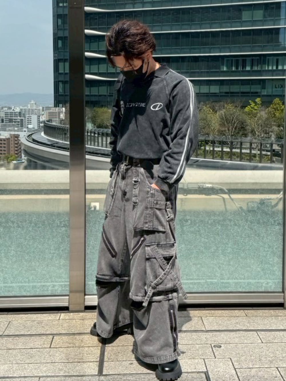 ブラック系のブルゾン、ブラック系のTシャツ/カットソー、ブラック系のカーゴパンツを着用したメンズの春コーディネートの3枚目の写真