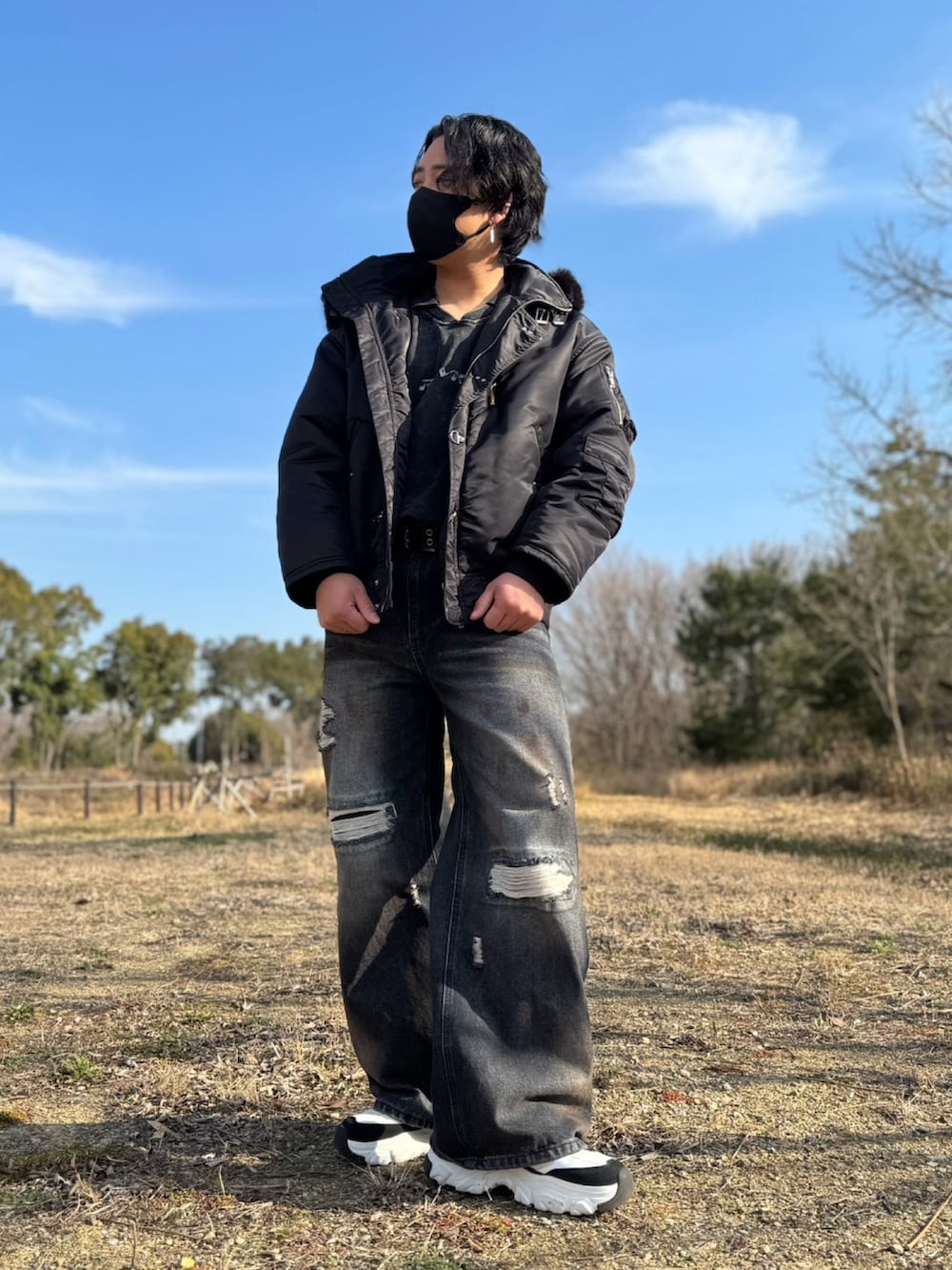 ブラック系のブルゾン、ブルー系のデニムパンツを着用したメンズの春コーディネートの3枚目の写真