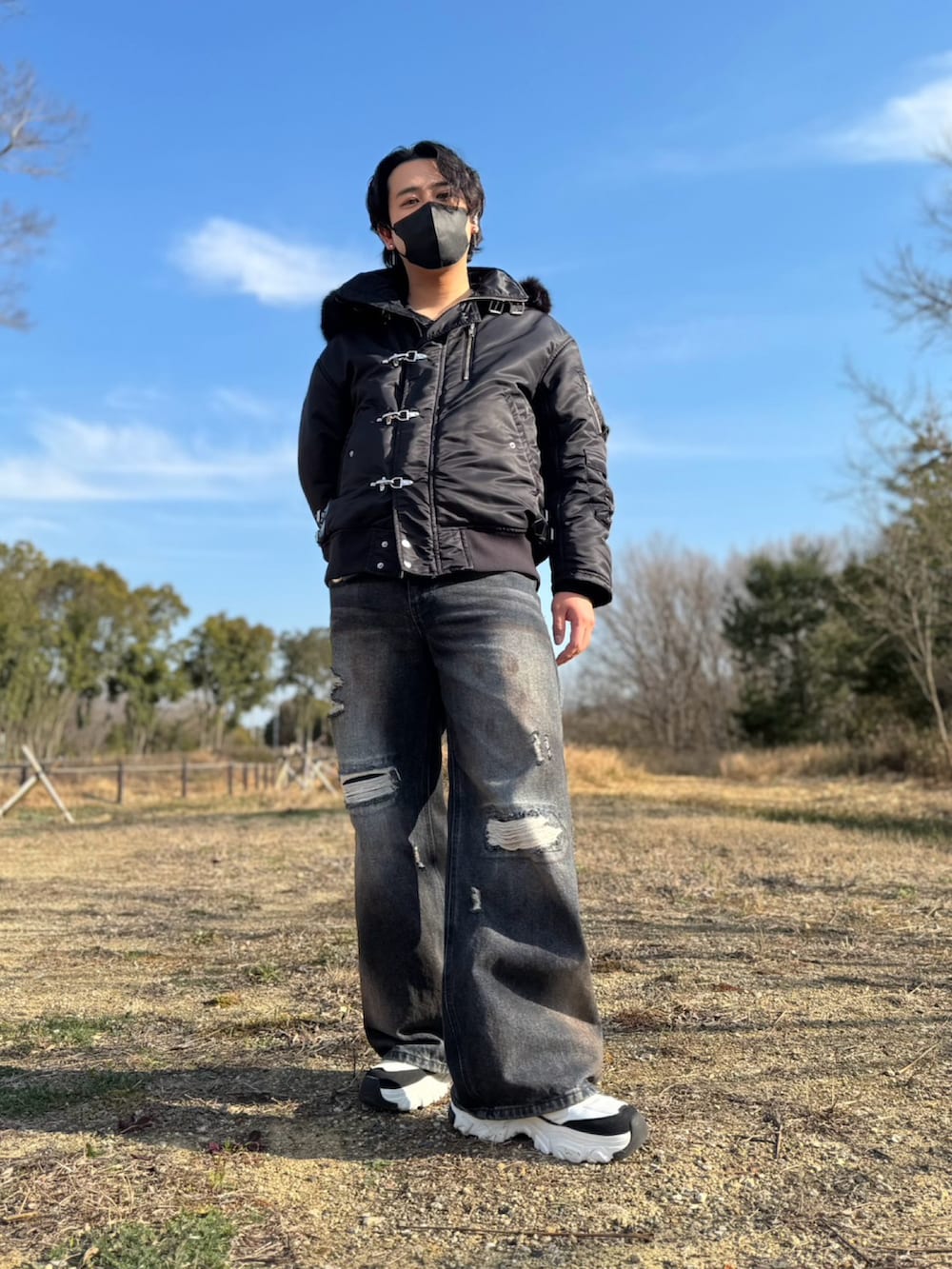 ブラック系のブルゾン、ブルー系のデニムパンツを着用したメンズの春コーディネートの2枚目の写真