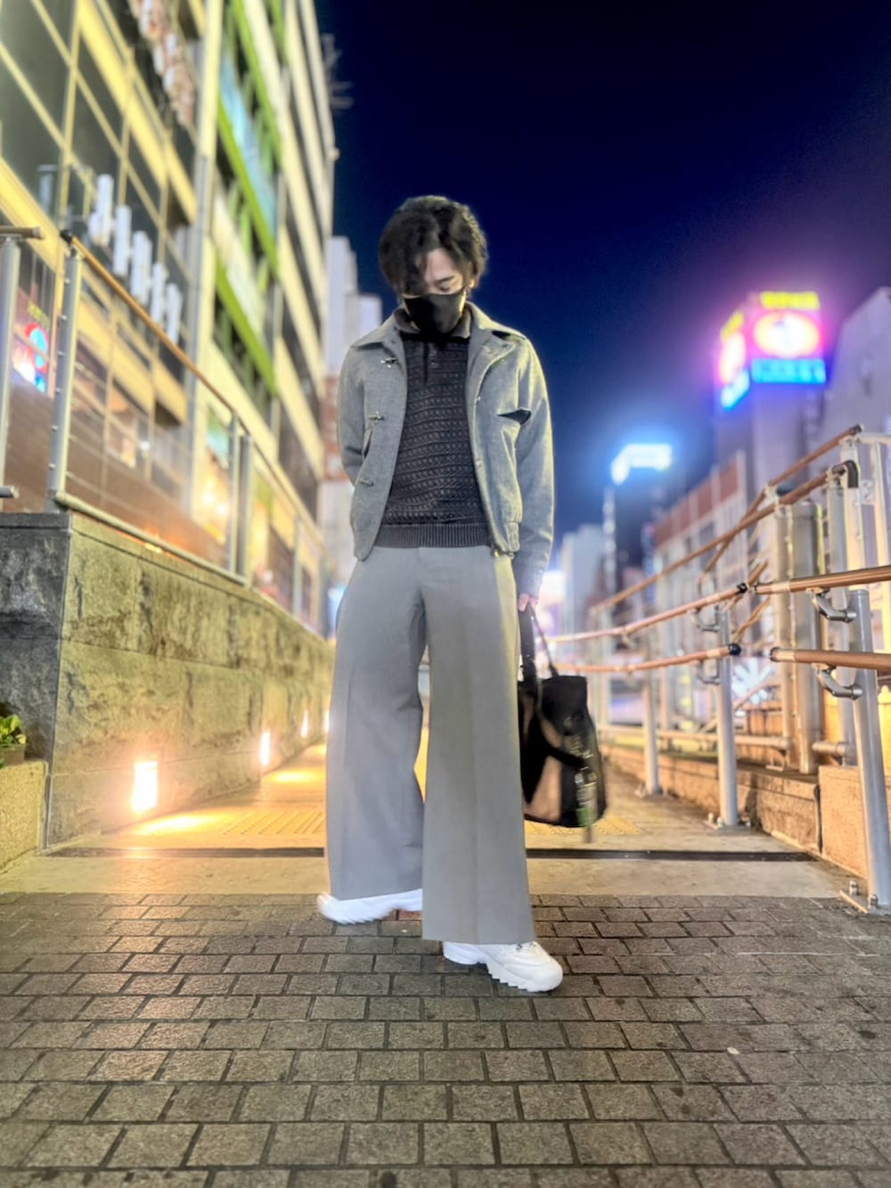 グレー系のブルゾン、グレー系のスラックス、ホワイト系のスニーカーを着用したメンズの冬コーディネートの3枚目の写真