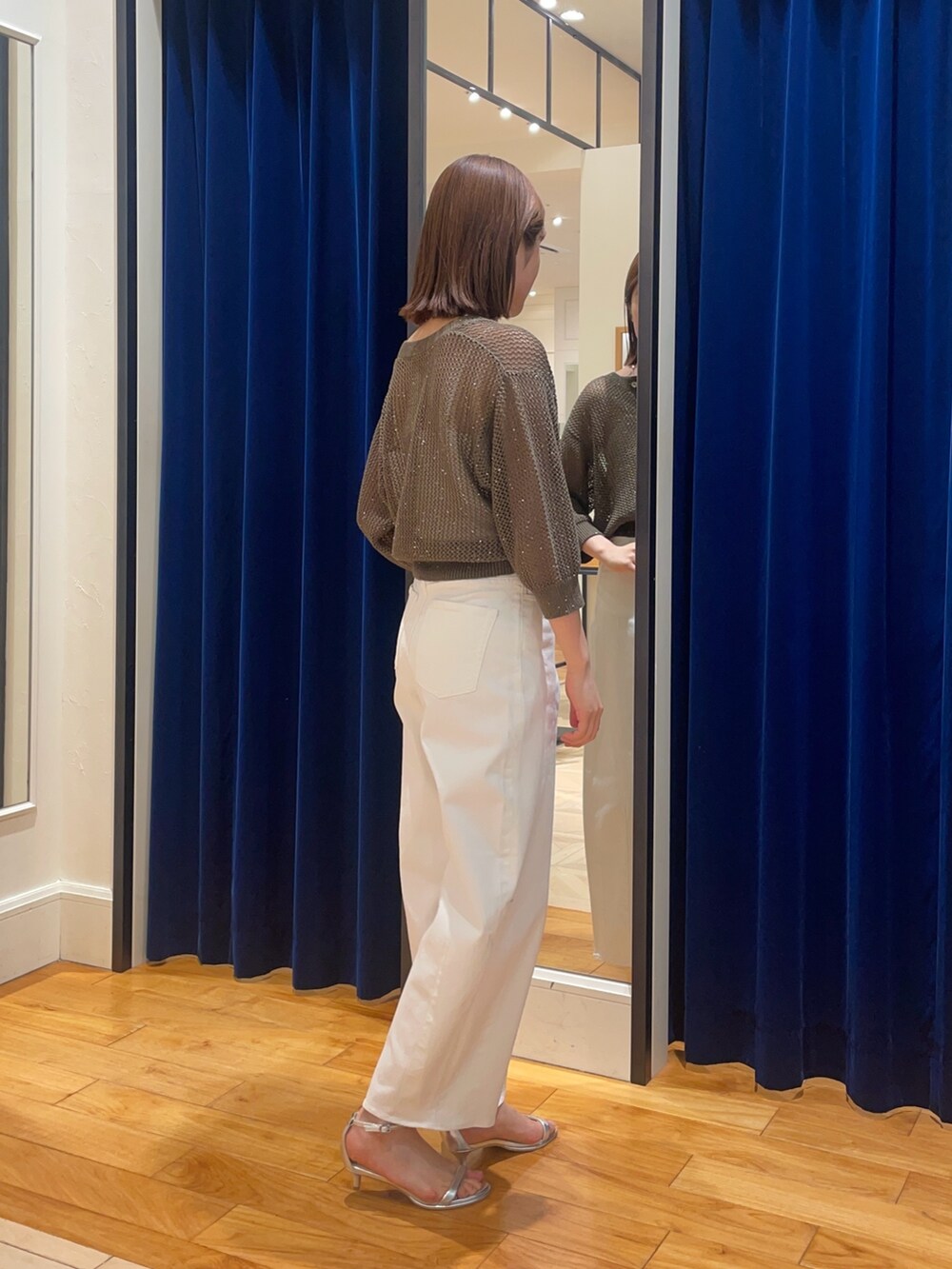 ホワイト系のデニムパンツ、シルバー系のサンダル、ブラウン系のカーディガン/ボレロを着用したレディースの春コーディネートの4枚目の写真