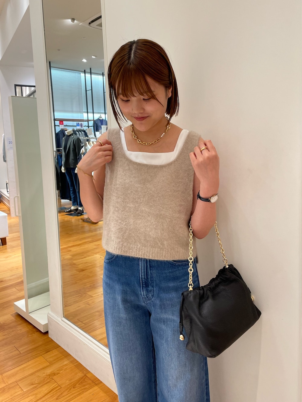 ブルー系のデニムパンツ、イエロー系のベスト、ホワイト系のタンクトップを着用したレディースの夏コーディネートの5枚目の写真