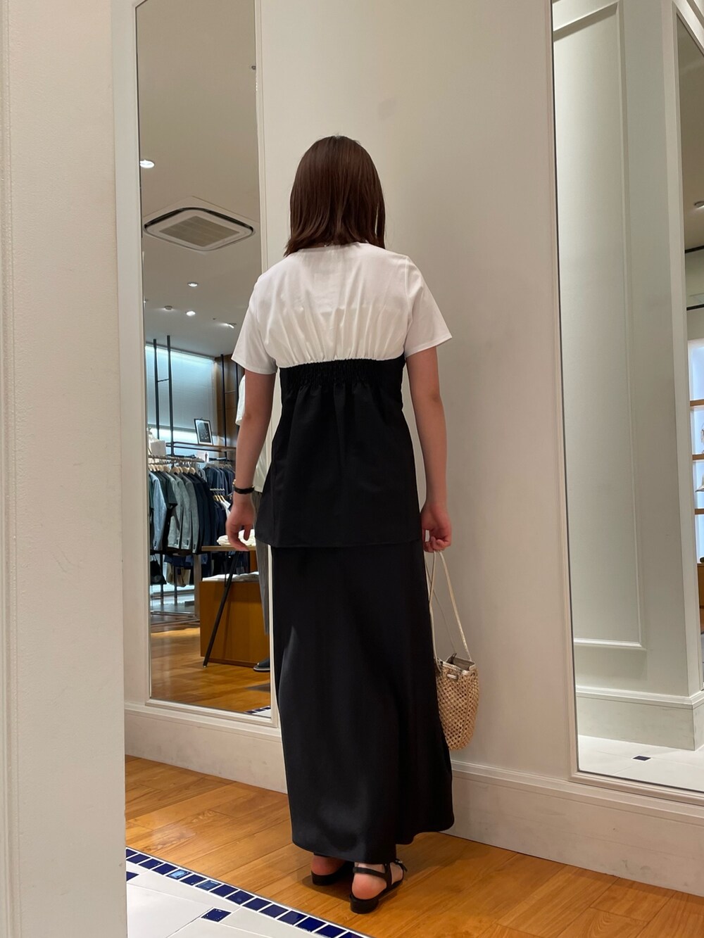 ブラック系のTシャツ/カットソー、ブラック系のスカート、ブラック系のサンダルを着用したレディースの春コーディネートの4枚目の写真