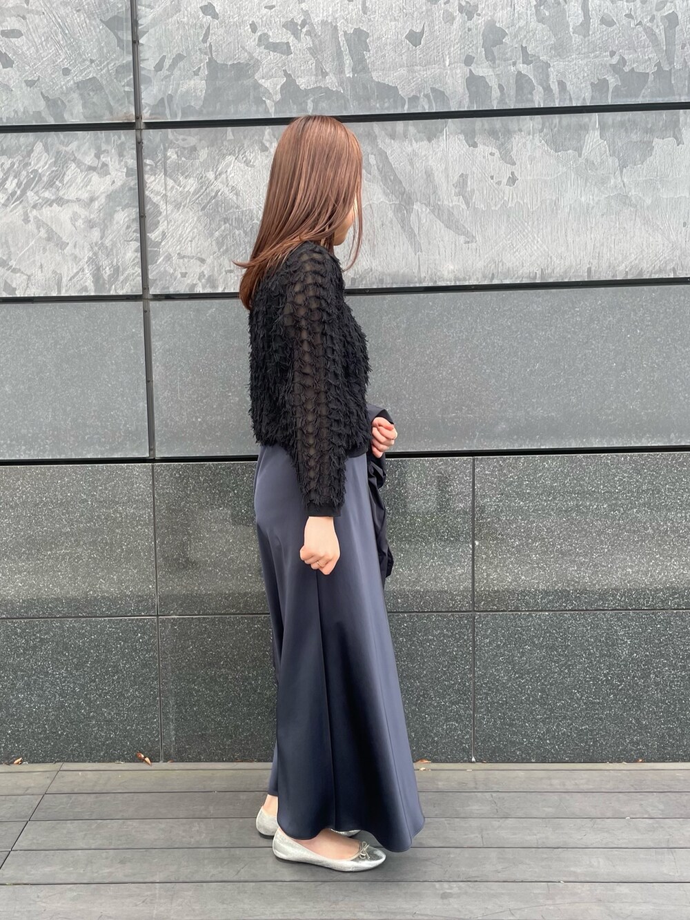 ブルー系のスカート、ブラック系のカーディガン/ボレロ、ブラック系のタンクトップを着用したレディースの春コーディネートの3枚目の写真