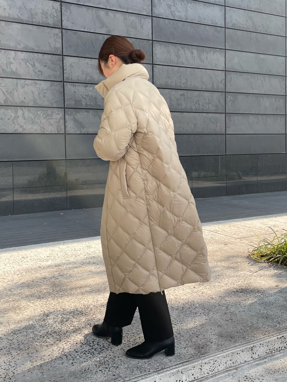 ホワイト系のニット/セーター、ブラック系のその他パンツ、ベージュ系のダウンジャケット/コートを着用したレディースの秋コーディネートの3枚目の写真