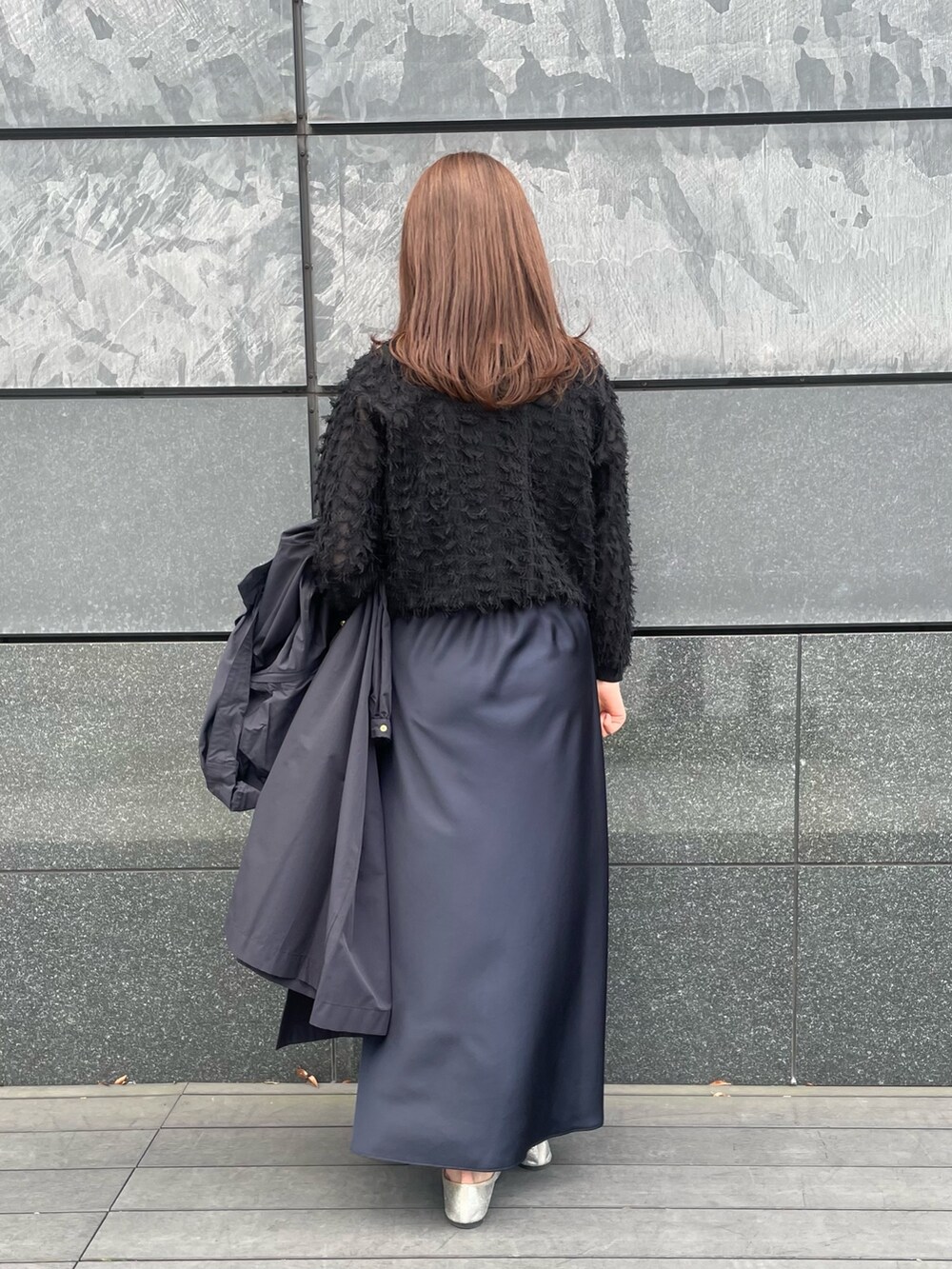 ブルー系のスカート、ブラック系のカーディガン/ボレロ、ブラック系のタンクトップを着用したレディースの春コーディネートの4枚目の写真