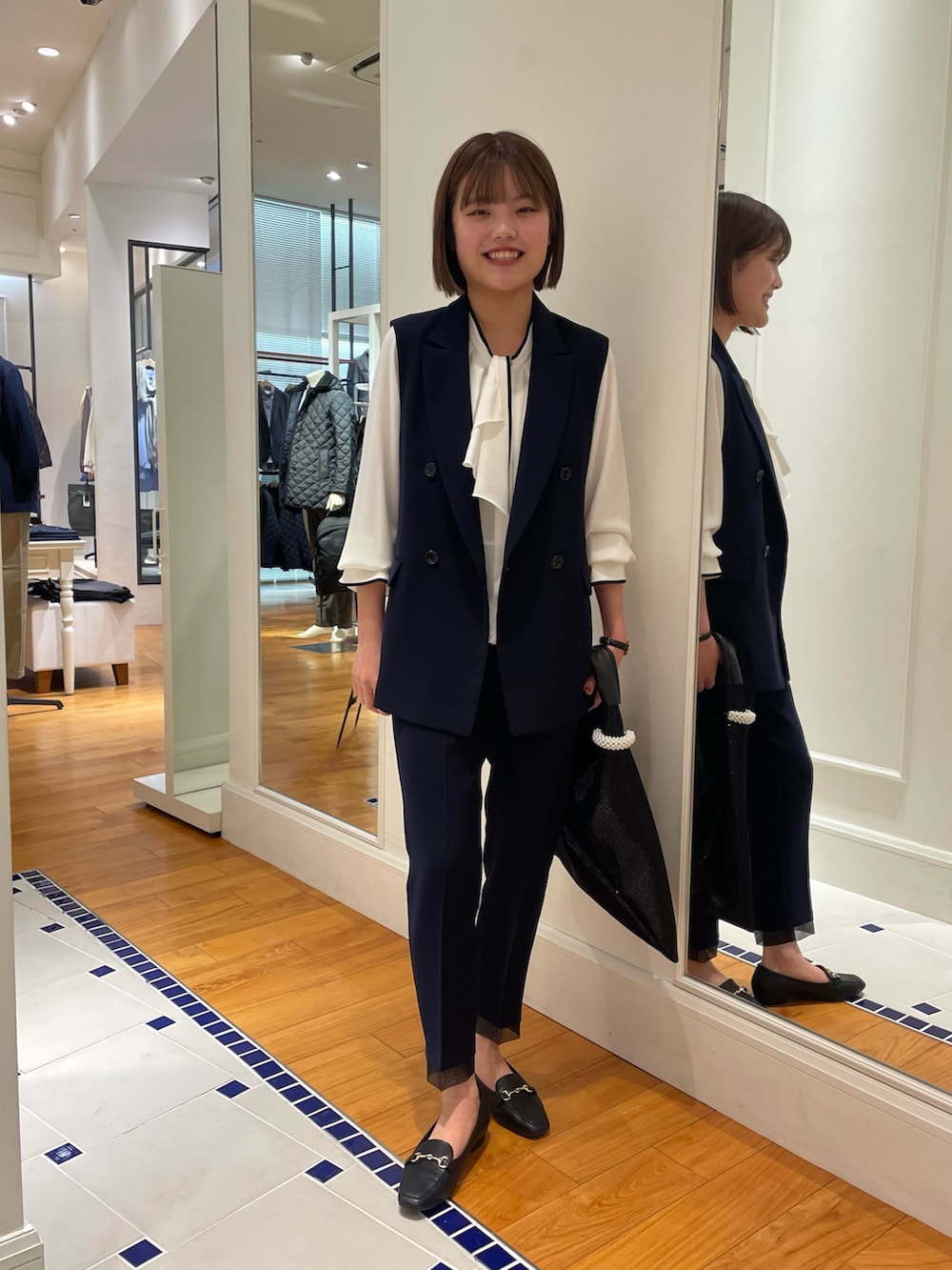 ブルー系のベスト、ブルー系のその他パンツ、ホワイト系のシャツ/ブラウスを着用したレディースの冬コーディネートの2枚目の写真