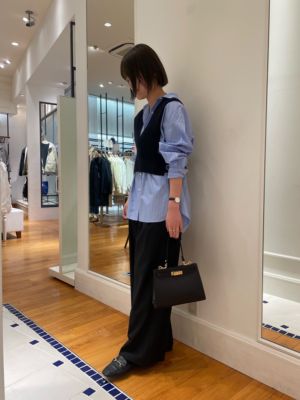 ブラック系のニット/セーター、ブルー系のシャツ/ブラウス、ブラック系のその他パンツを着用したレディースの冬コーディネートの3枚目の写真