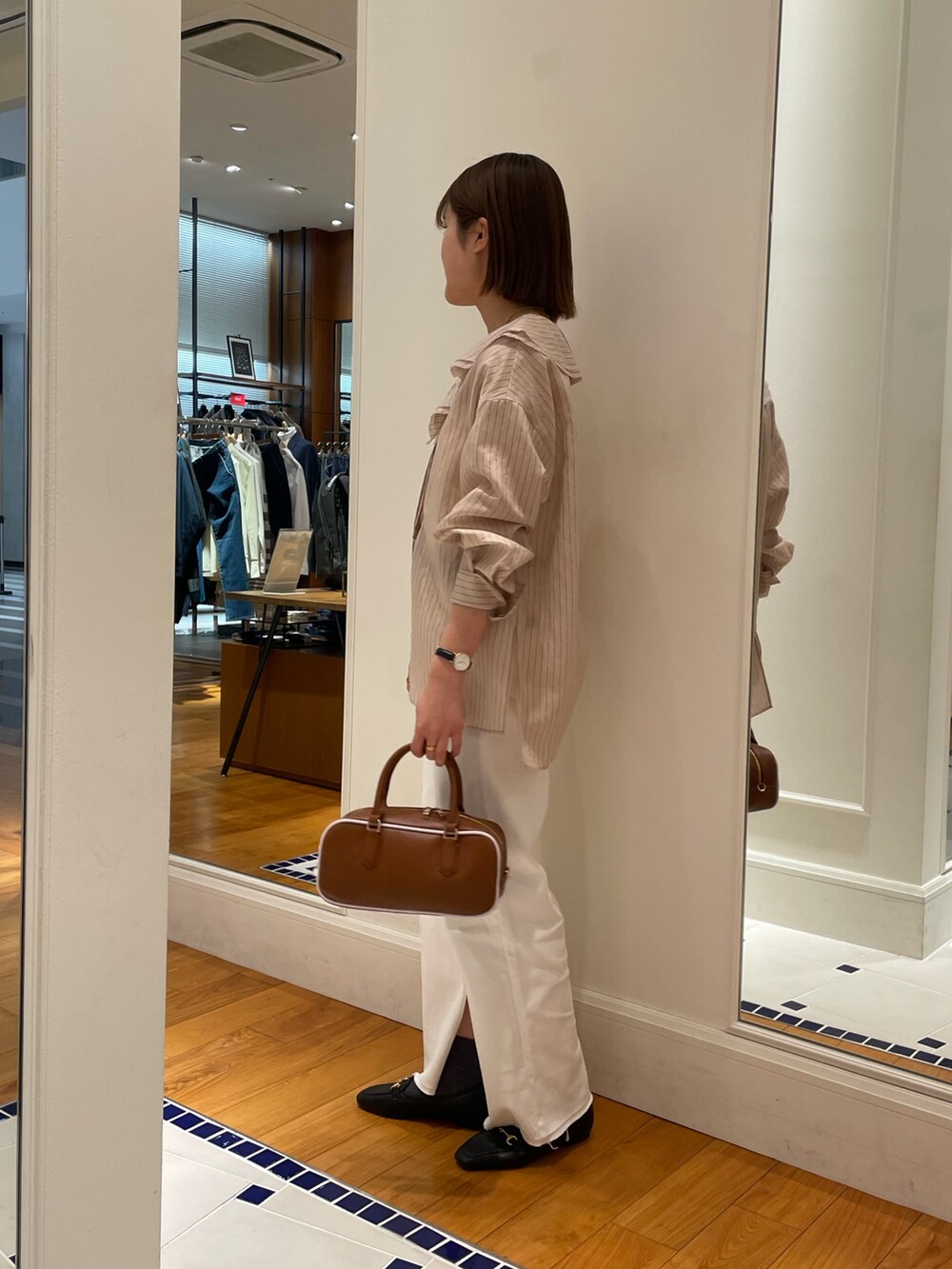 ベージュ系のシャツ/ブラウス、ホワイト系のデニムパンツ、イエロー系のボストンバッグを着用したレディースの冬コーディネートの3枚目の写真