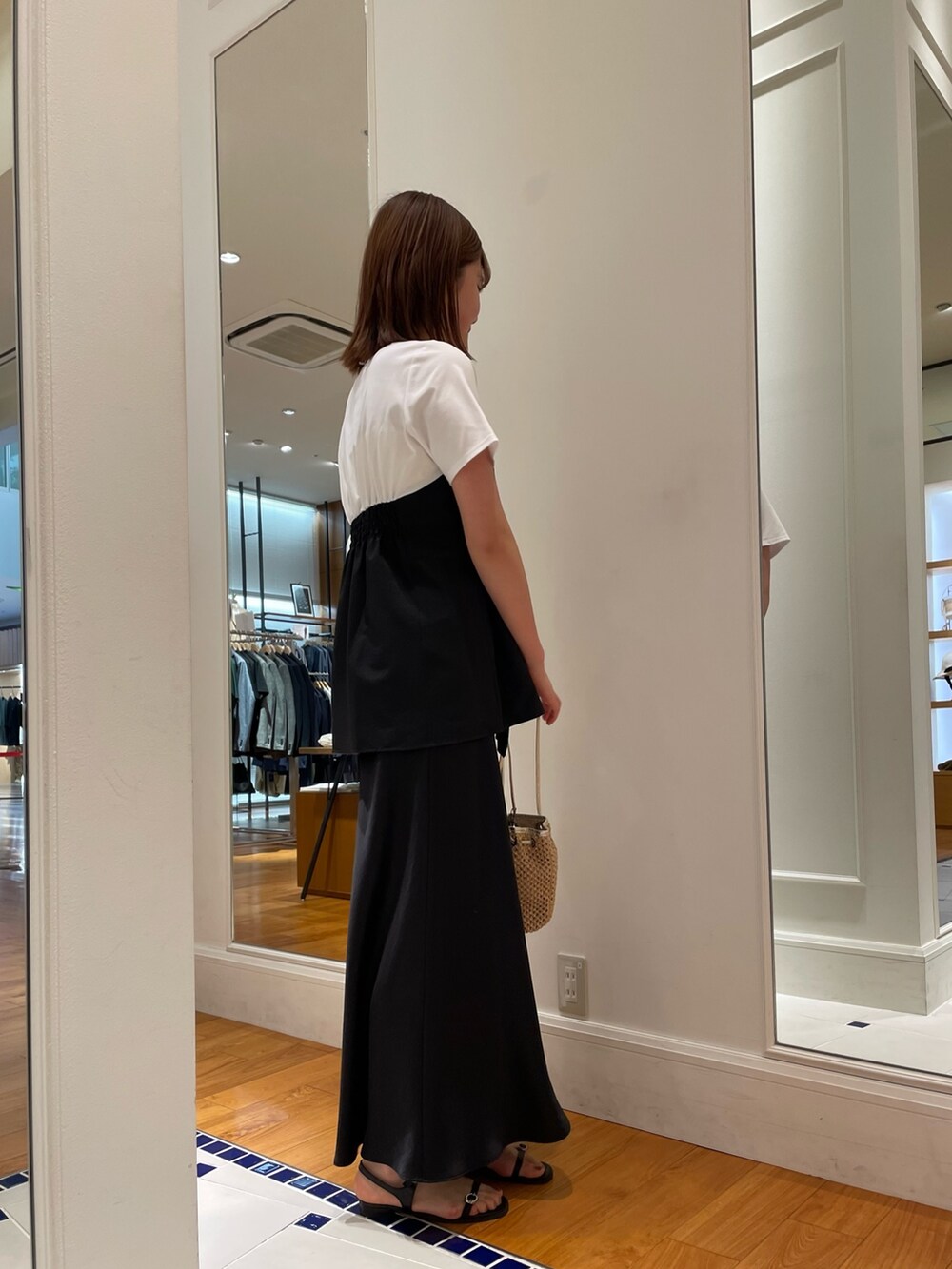 ブラック系のTシャツ/カットソー、ブラック系のスカート、ブラック系のサンダルを着用したレディースの春コーディネートの3枚目の写真