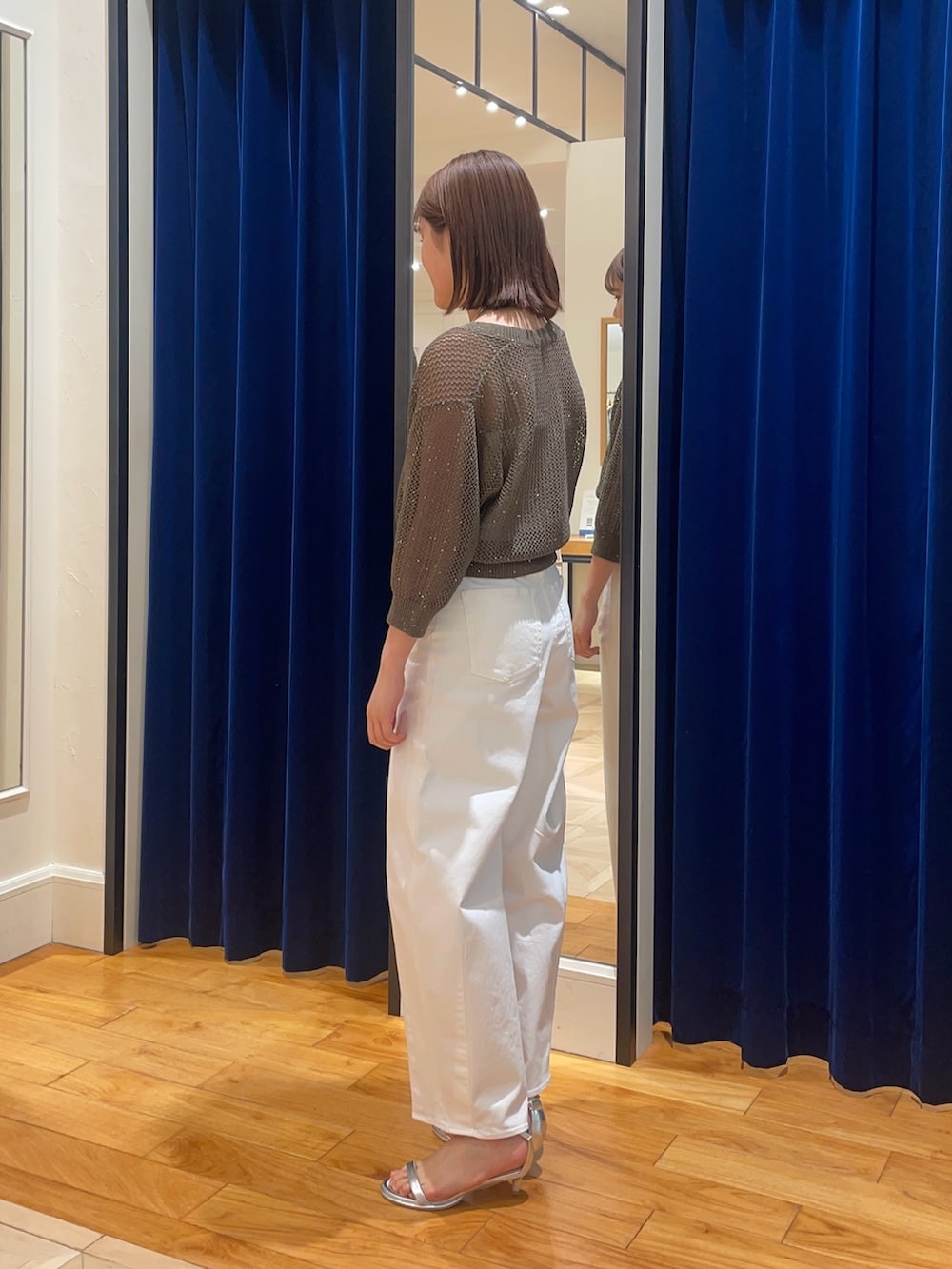 ホワイト系のデニムパンツ、シルバー系のサンダル、ブラウン系のカーディガン/ボレロを着用したレディースの春コーディネートの3枚目の写真