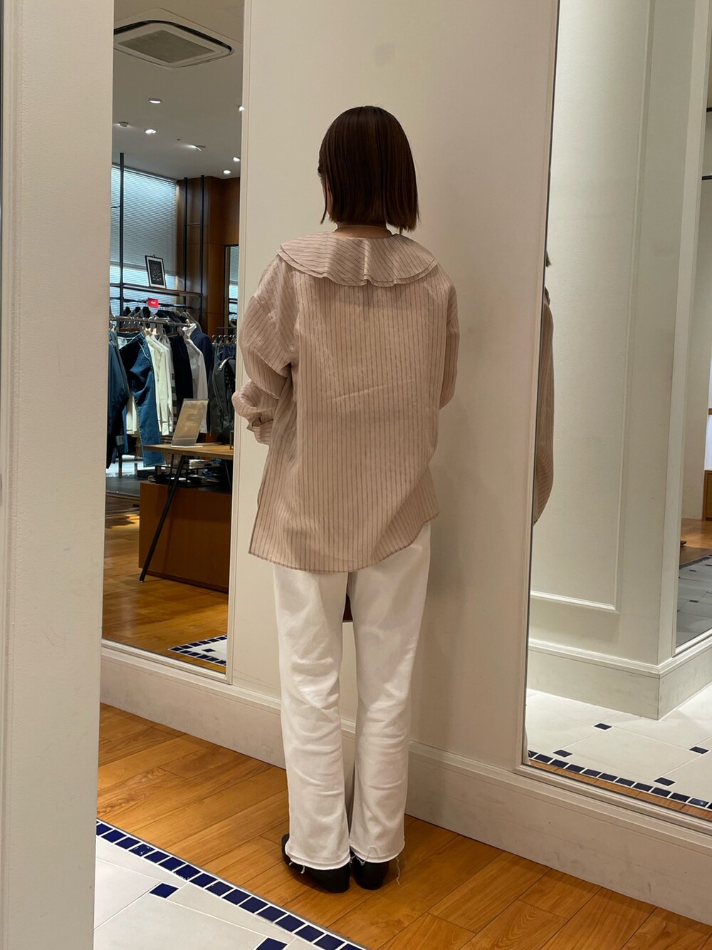 ベージュ系のシャツ/ブラウス、ホワイト系のデニムパンツ、イエロー系のボストンバッグを着用したレディースの冬コーディネートの4枚目の写真