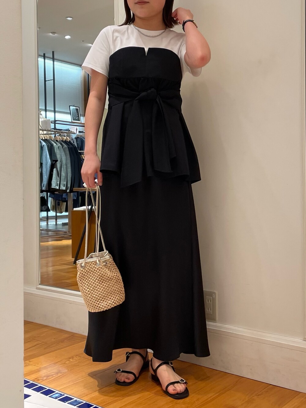 ブラック系のTシャツ/カットソー、ブラック系のスカート、ブラック系のサンダルを着用したレディースの春コーディネートの2枚目の写真