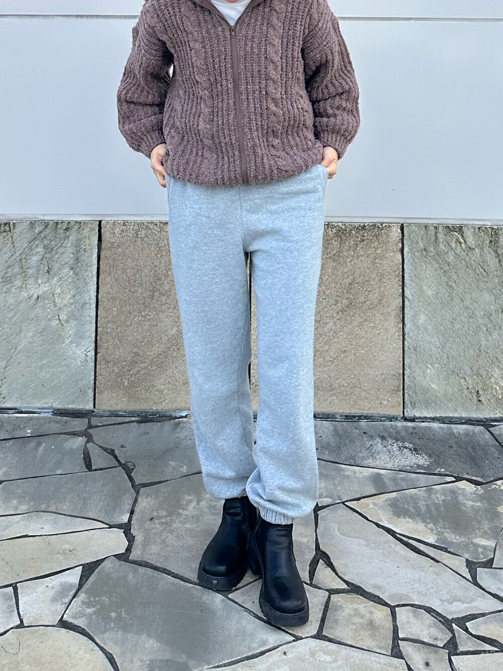 グレー系のスウェットパンツ、ブラック系のシューズ、ブラウン系のニット/セーターを着用したレディースの冬コーディネートの2枚目の写真