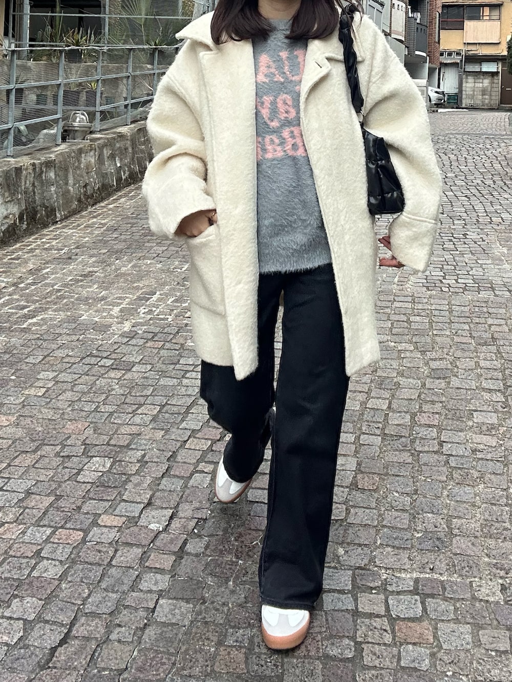 ブラック系のパンツ、ホワイト系のスニーカー、ホワイト系のジャケット/アウターを着用したレディースの春コーディネートの2枚目の写真