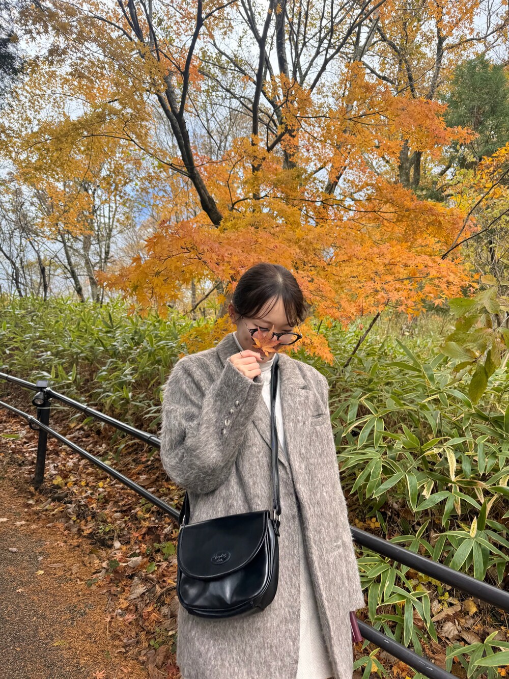 グレー系のジャケット/アウター、ブラック系のバッグ、ベージュ系のパンツを着用したレディースの秋コーディネートの3枚目の写真