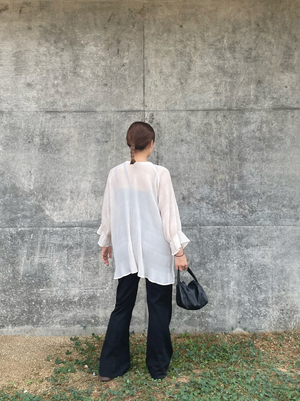 ホワイト系のトップス、ブラック系のパンツ、ブラック系のショルダーバッグを着用したレディースの夏コーディネートの2枚目の写真