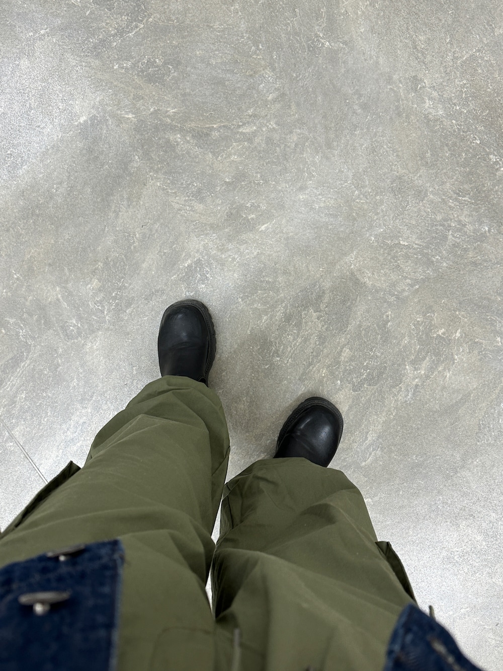 グリーン系のパンツ、ブルー系のデニムジャケット、ブラック系のシューズを着用したレディースの春コーディネートの2枚目の写真