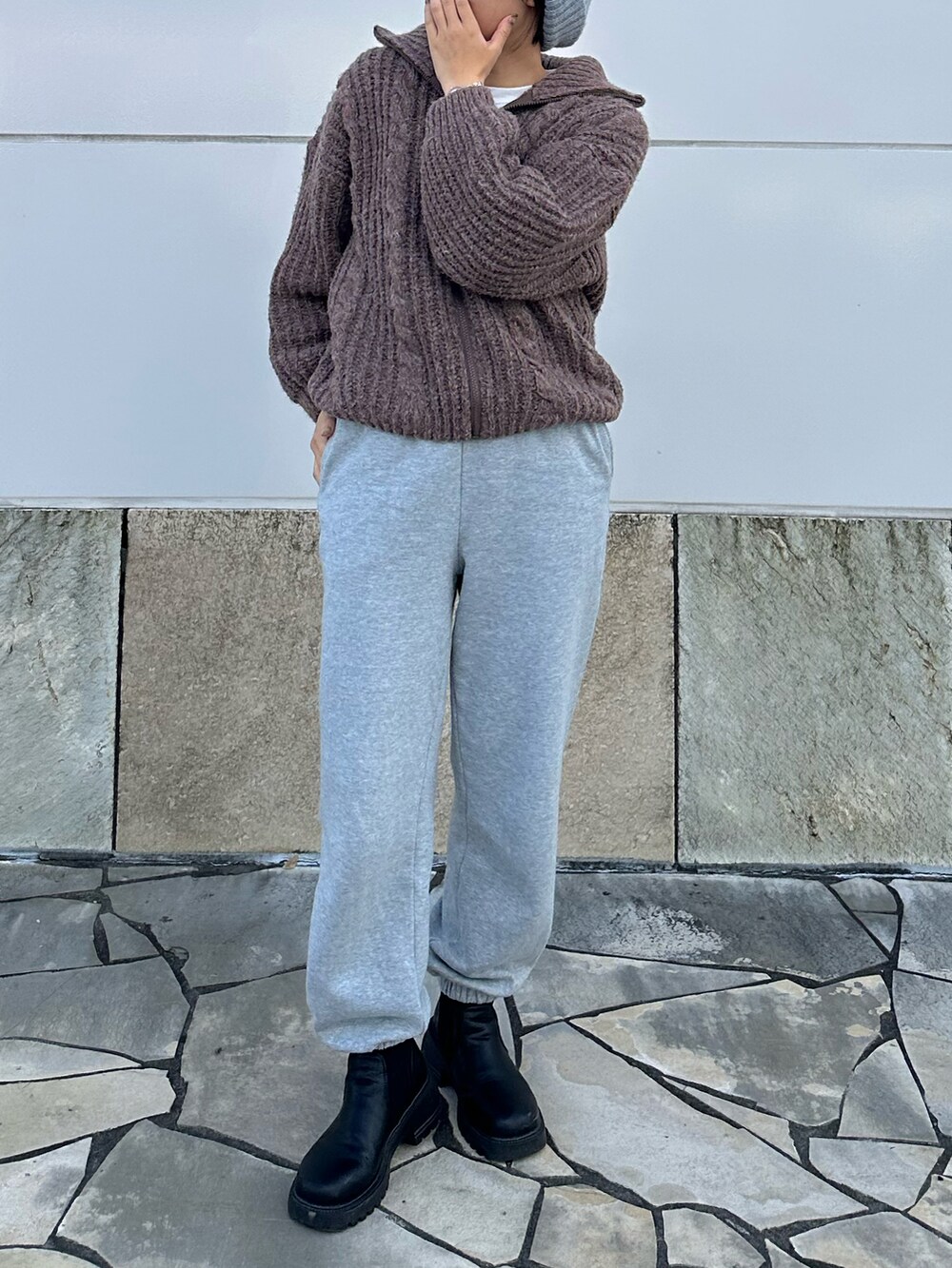 グレー系のスウェットパンツ、ブラック系のシューズ、ブラウン系のニット/セーターを着用したレディースの冬コーディネートの3枚目の写真