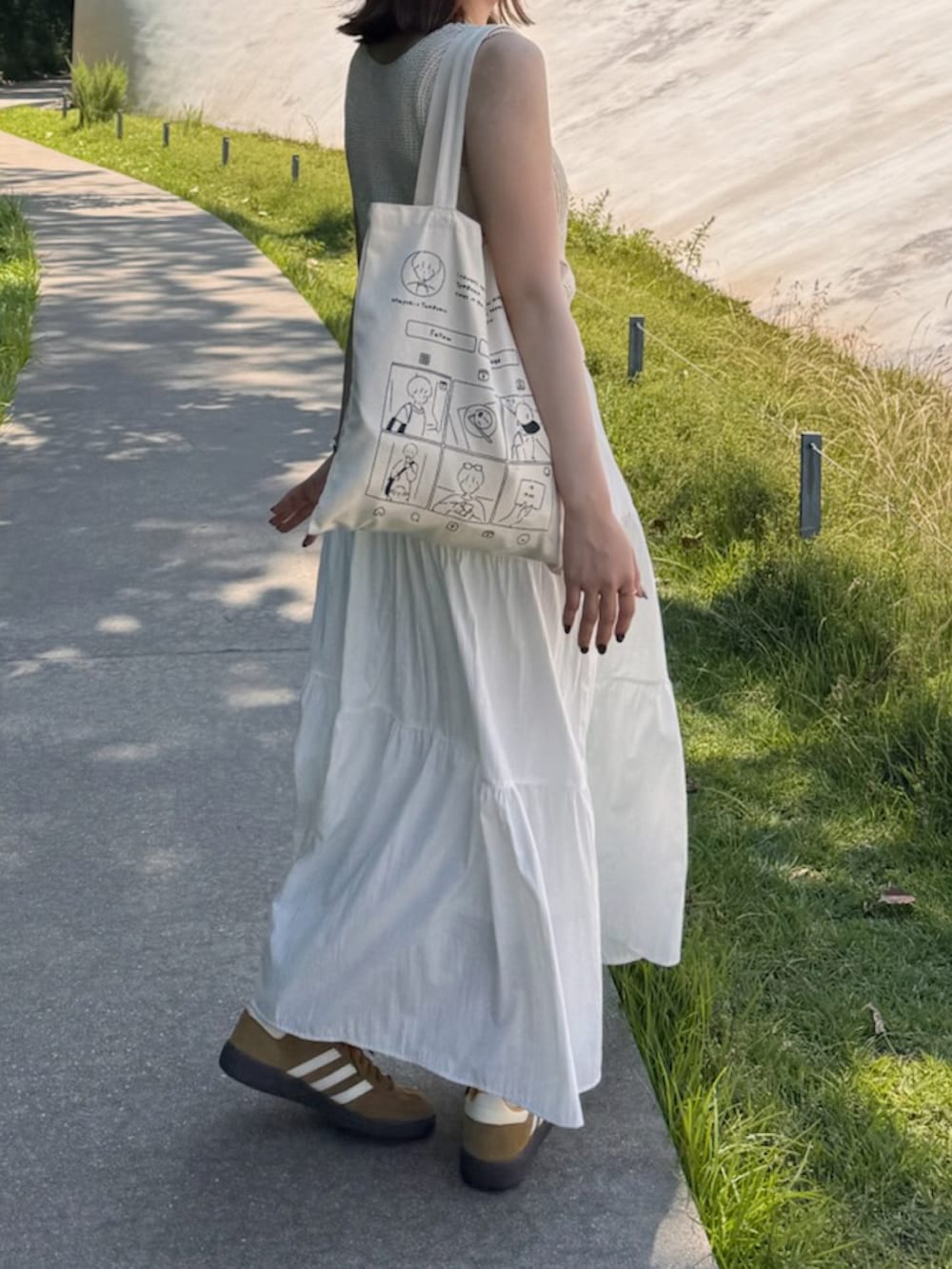 ホワイト系のスカート、ベージュ系のトップスを着用したレディースの秋コーディネートの2枚目の写真