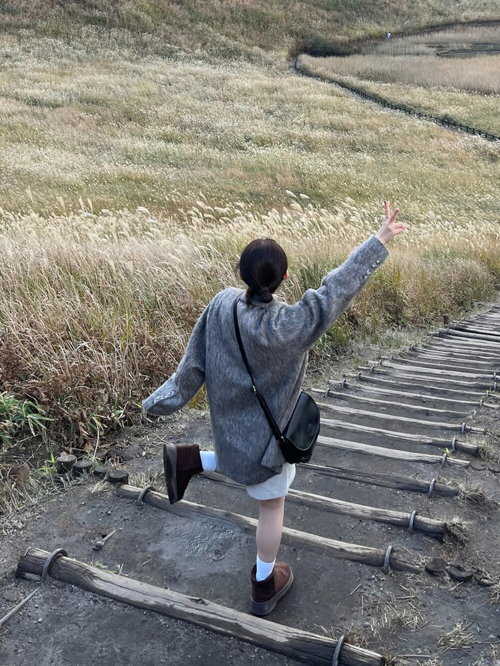 グレー系のジャケット/アウター、ブラック系のバッグ、ベージュ系のパンツを着用したレディースの秋コーディネートの2枚目の写真