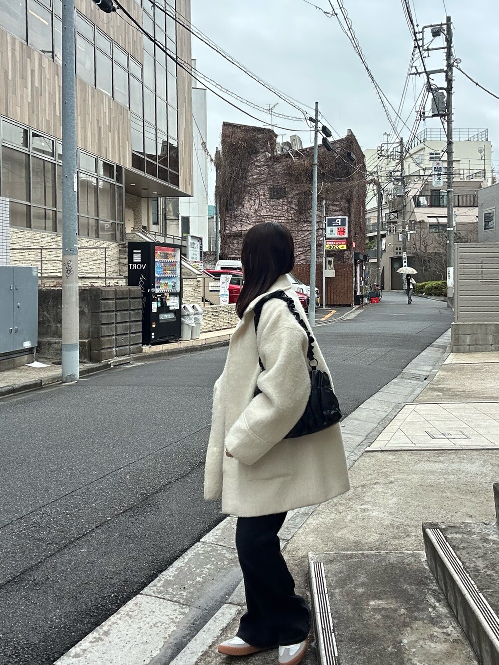 ブラック系のパンツ、ホワイト系のスニーカー、ホワイト系のジャケット/アウターを着用したレディースの春コーディネートの3枚目の写真