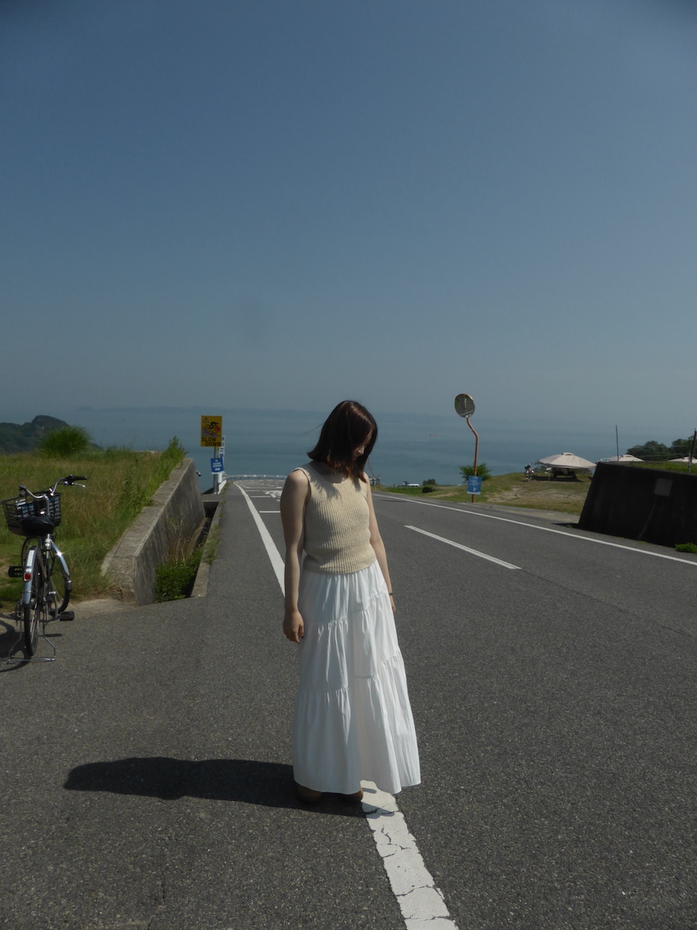 ホワイト系のスカート、ベージュ系のトップスを着用したレディースの秋コーディネートの3枚目の写真