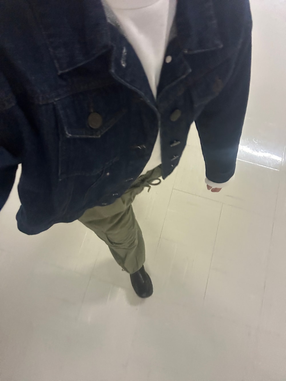 グリーン系のパンツ、ブルー系のデニムジャケット、ブラック系のシューズを着用したレディースの春コーディネートの3枚目の写真