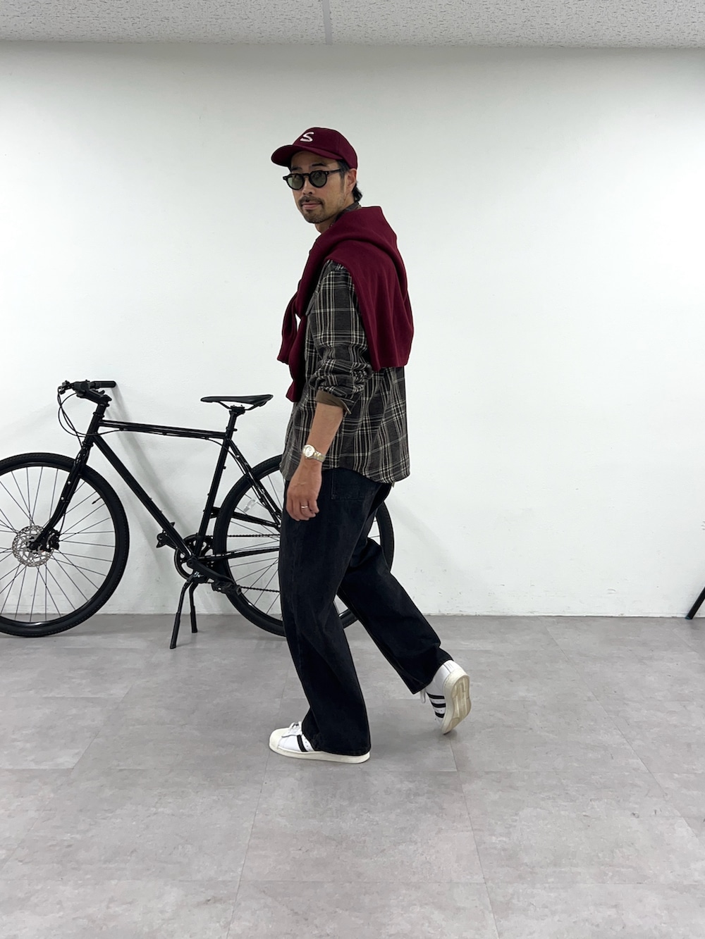 ブラウン系のシャツ/ブラウス、ブラック系のデニムパンツ、レッド系のキャップを着用したメンズの秋コーディネートの2枚目の写真