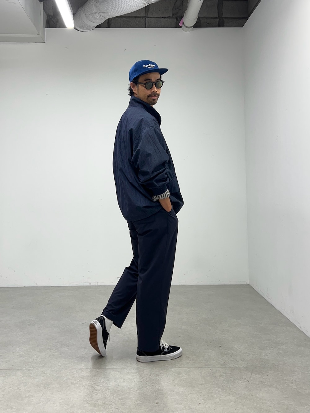 ブルー系のナイロンジャケット、ブルー系のその他パンツ、ブルー系のキャップを着用したメンズの夏コーディネートの2枚目の写真