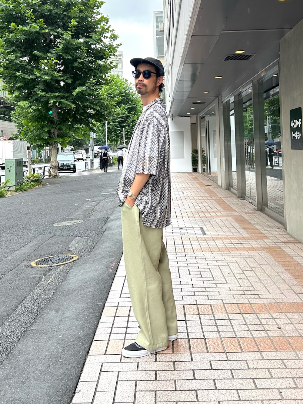 グレー系のシャツ/ブラウス、グリーン系のスラックス、ホワイト系のTシャツ/カットソーを着用したメンズの夏コーディネートの4枚目の写真