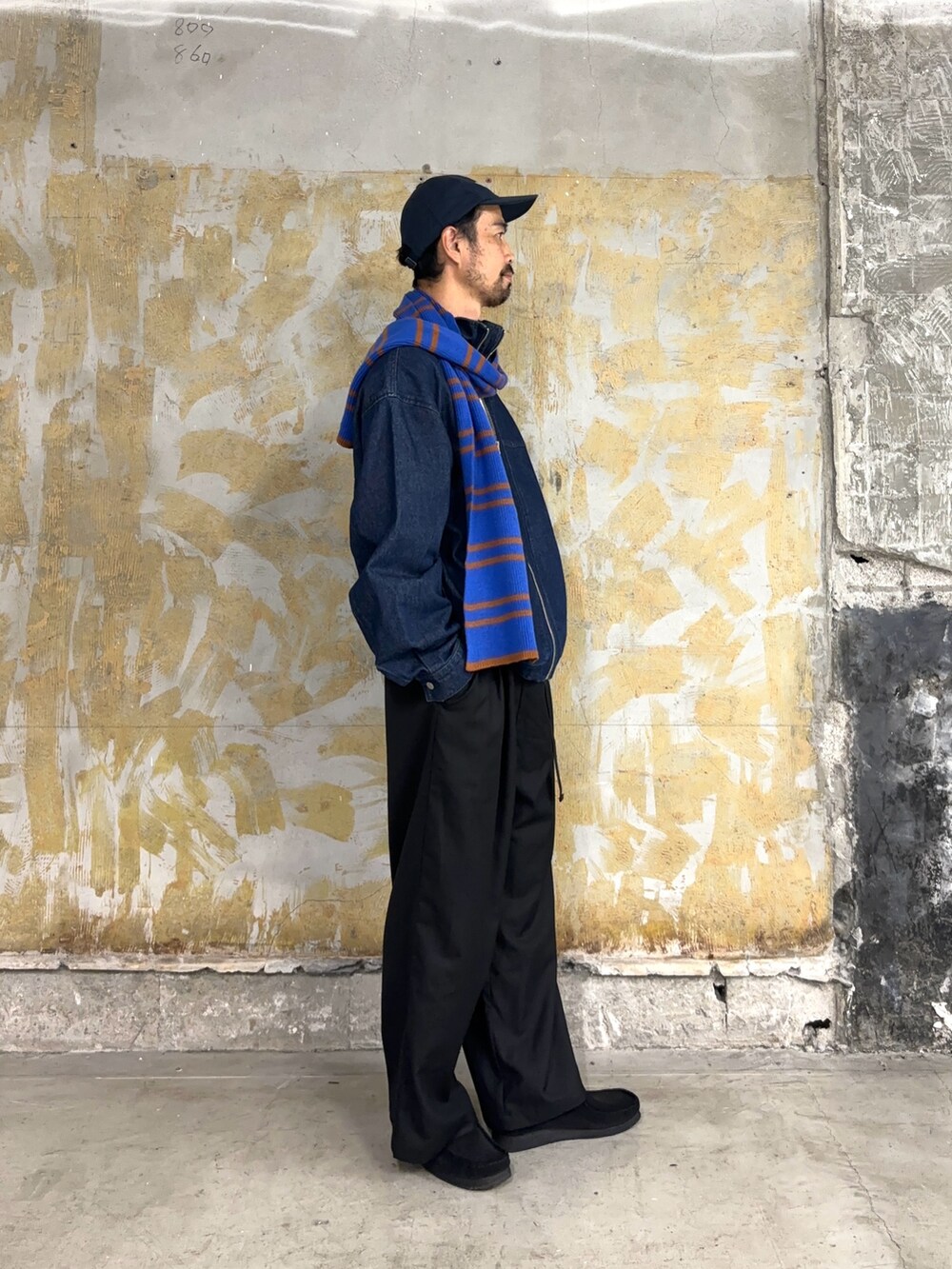 ブルー系のデニムジャケット、ブルー系のマフラーを着用したメンズの秋コーディネートの2枚目の写真